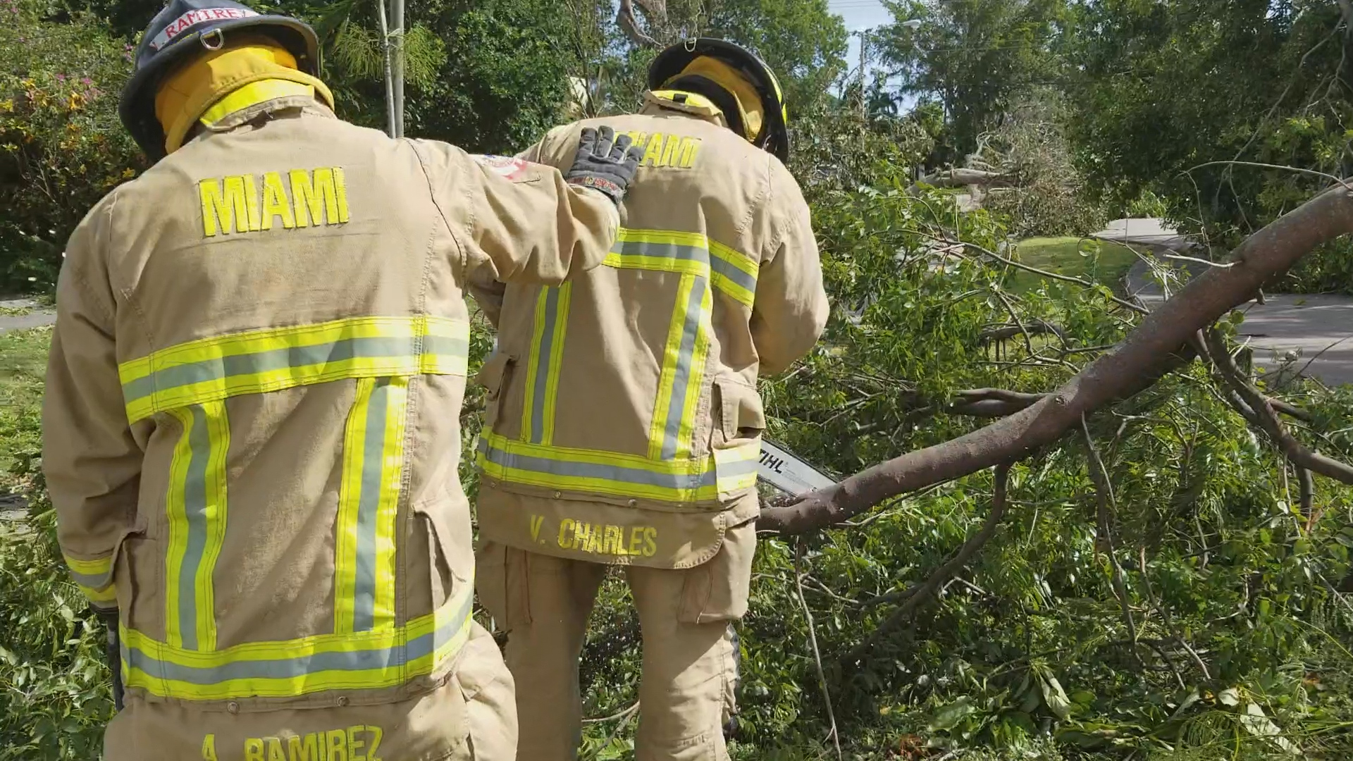 Miami Firefighters cut teams clear debris and downed trees post Hurricane in order to restore traffic flow. 