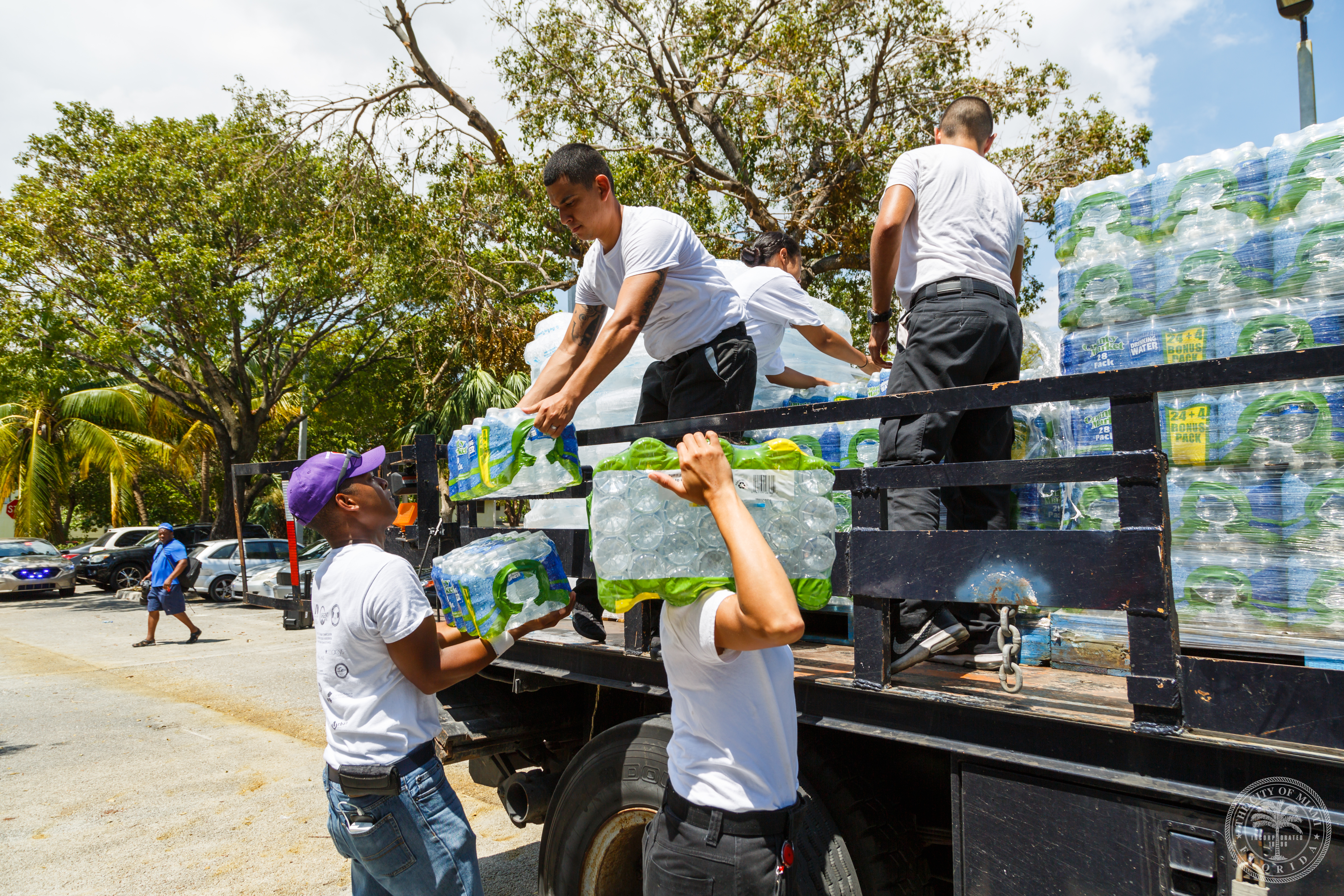 city staff unloading packages of water bottles off a truck