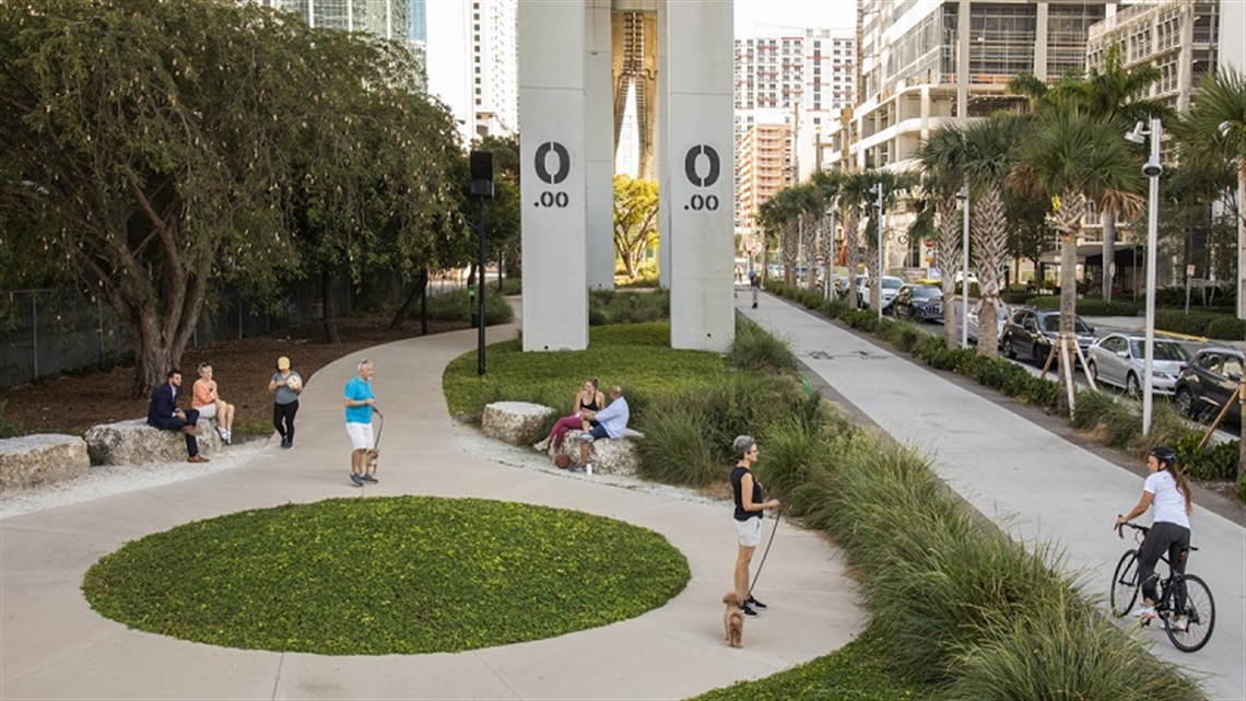 Photo of kids playing in the underline park with grass next to the street 